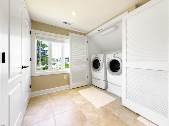 washroom with washing machine and dryer and light tile patterned flooring