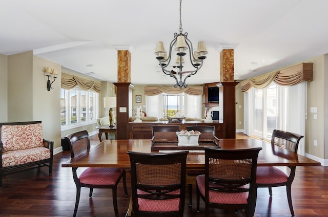 dining space with a healthy amount of sunlight, dark hardwood / wood-style floors, a chandelier, and decorative columns