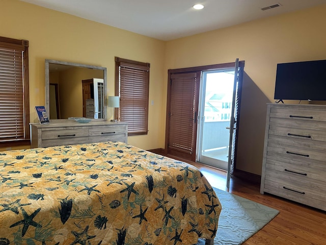 bedroom with access to outside and hardwood / wood-style floors