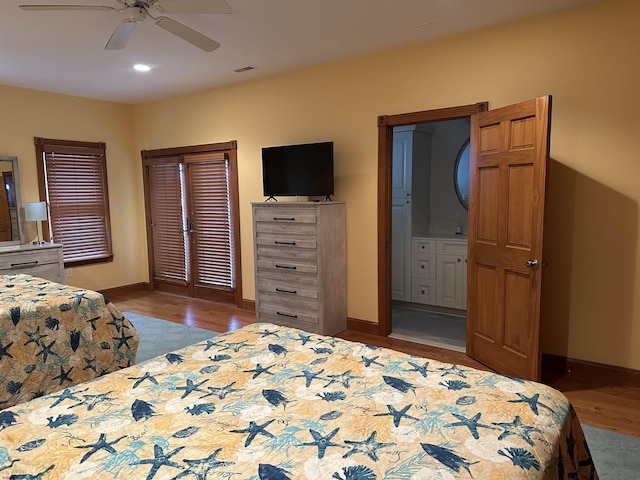 bedroom with ceiling fan, ensuite bathroom, and light wood-type flooring