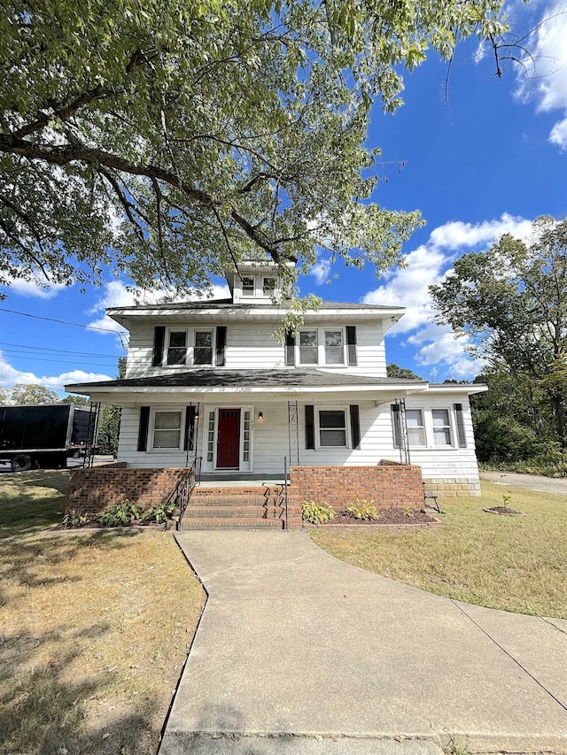 view of front property with covered porch and a front lawn