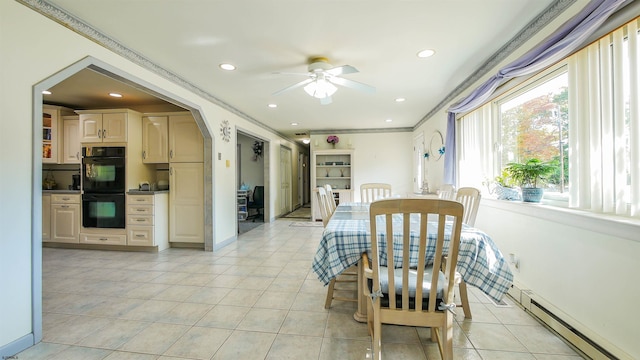 tiled dining area with ceiling fan, crown molding, plenty of natural light, and a baseboard radiator