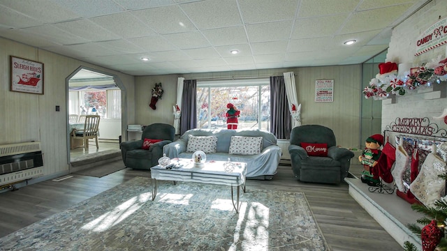 living room with plenty of natural light, heating unit, and hardwood / wood-style floors