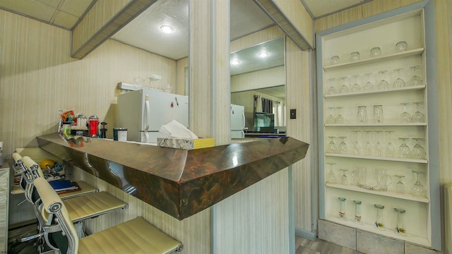 bar with built in shelves and white refrigerator