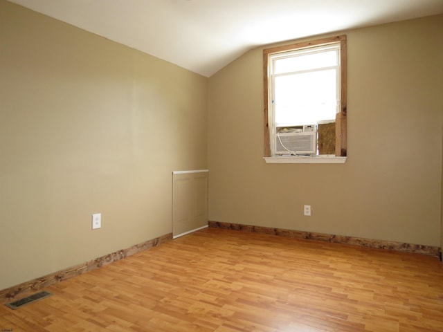 additional living space featuring vaulted ceiling, cooling unit, and light hardwood / wood-style flooring