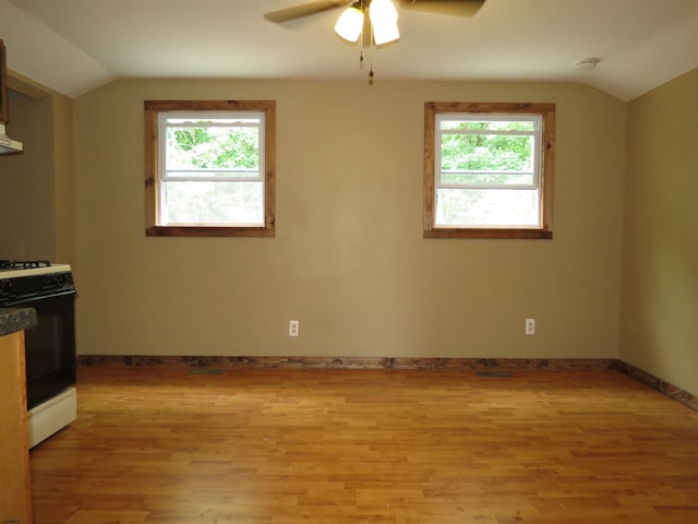 kitchen with light hardwood / wood-style floors, lofted ceiling, and white gas range oven