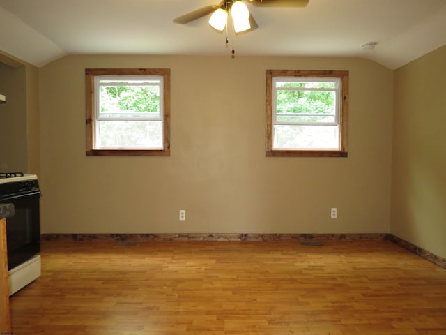 interior space with lofted ceiling, ceiling fan, range with gas stovetop, and light hardwood / wood-style floors