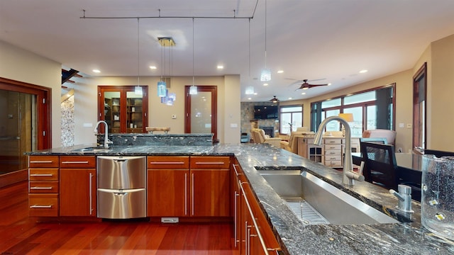 kitchen featuring decorative light fixtures, sink, ceiling fan, and dark stone countertops