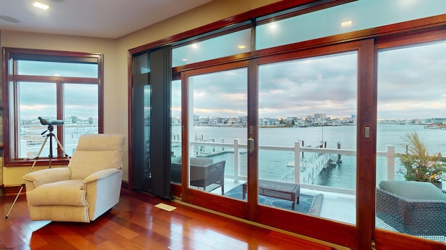 doorway to outside featuring hardwood / wood-style flooring and a water view