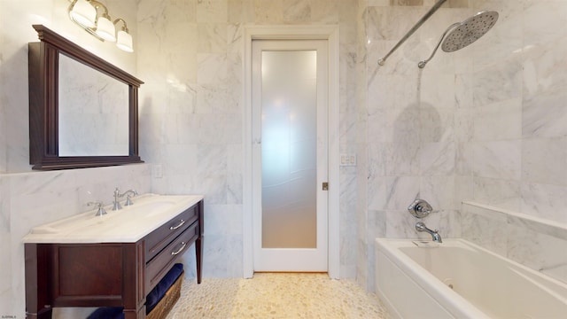 bathroom with vanity, tile walls, and bathtub / shower combination