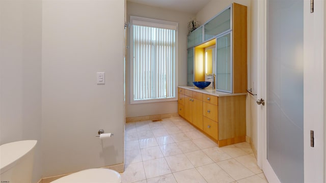 bathroom featuring toilet, tile patterned flooring, and sink