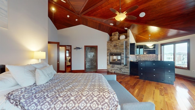 bedroom with ceiling fan, wood-type flooring, wood ceiling, and a fireplace