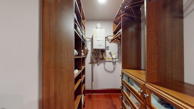 spacious closet with tankless water heater and dark hardwood / wood-style floors