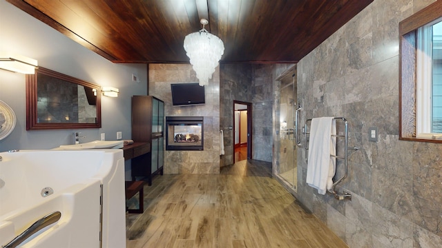 bathroom with wood ceiling, wood-type flooring, a fireplace, tile walls, and tiled shower