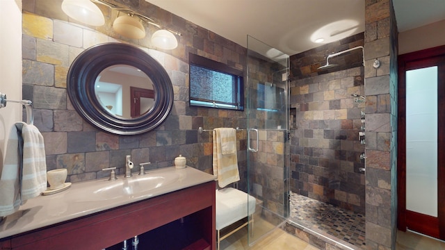 bathroom featuring an enclosed shower, vanity, tile walls, and backsplash