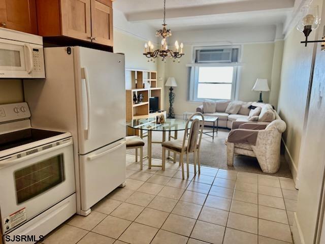 kitchen with beam ceiling, a wall unit AC, light tile patterned floors, an inviting chandelier, and white appliances