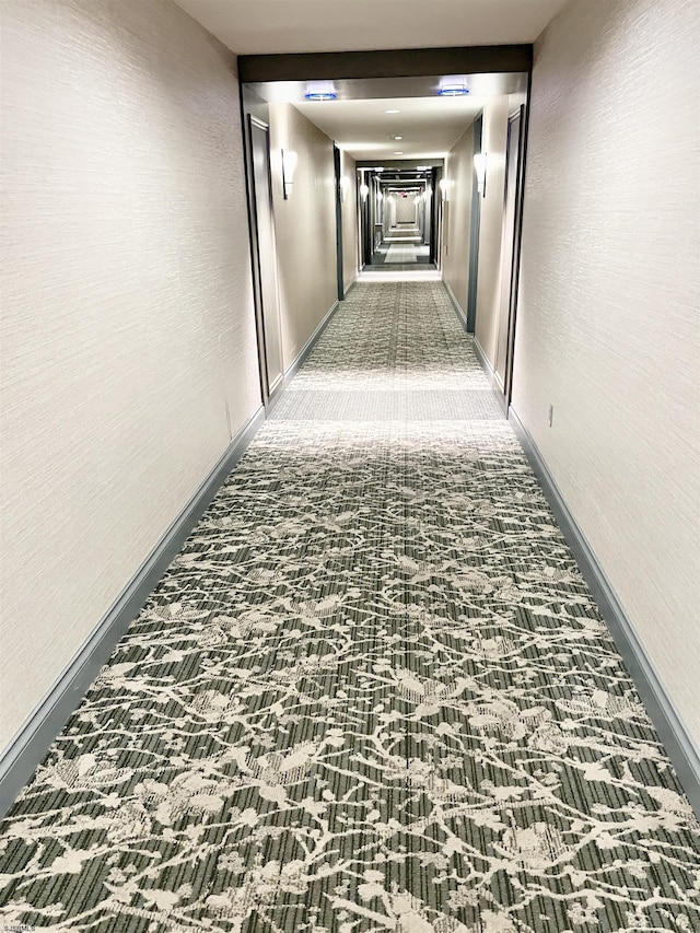 hallway featuring dark carpet