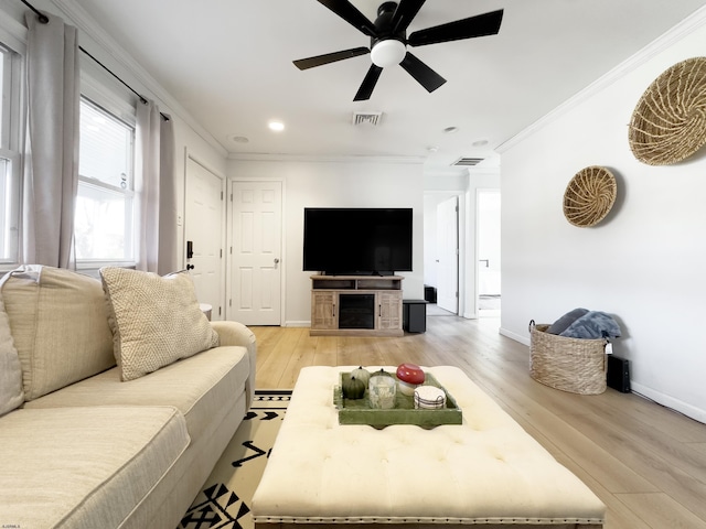 living room with light wood-type flooring, ceiling fan, and ornamental molding