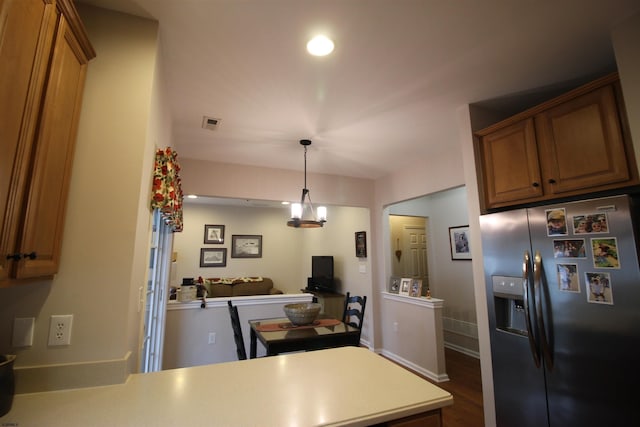 kitchen featuring stainless steel fridge, a notable chandelier, wood-type flooring, decorative light fixtures, and kitchen peninsula