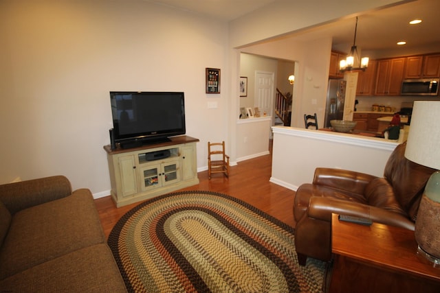 living room with dark hardwood / wood-style flooring and a chandelier