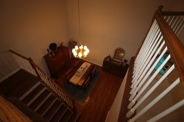 stairway with an inviting chandelier and hardwood / wood-style flooring