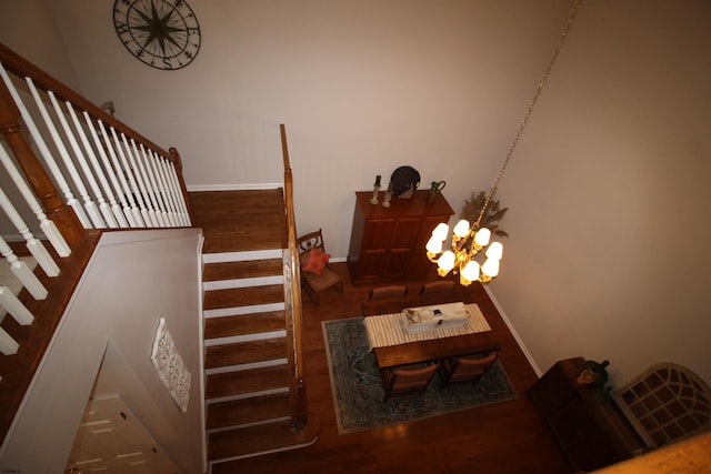 staircase featuring an inviting chandelier and wood-type flooring