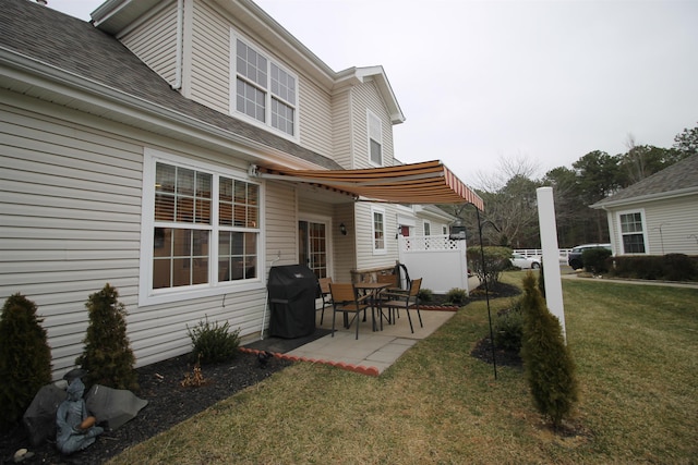 rear view of house featuring a lawn and a patio