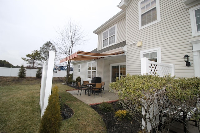 rear view of house with a patio and a yard