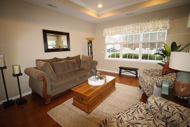 living room featuring a raised ceiling, crown molding, and dark hardwood / wood-style floors