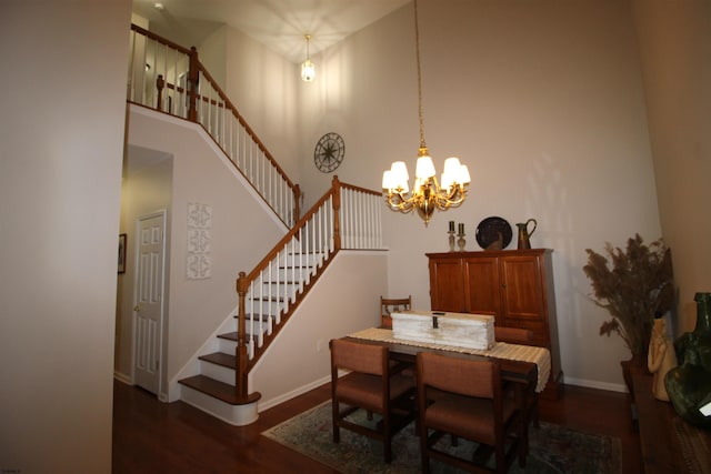 dining space with a high ceiling, dark wood-type flooring, and a chandelier