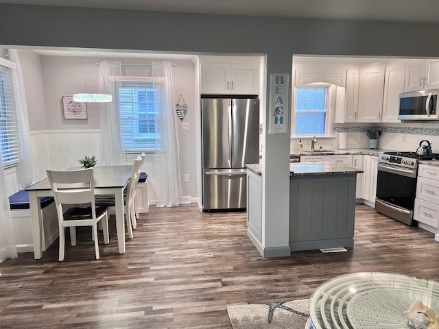 kitchen featuring white cabinets, dark stone counters, sink, and stainless steel appliances