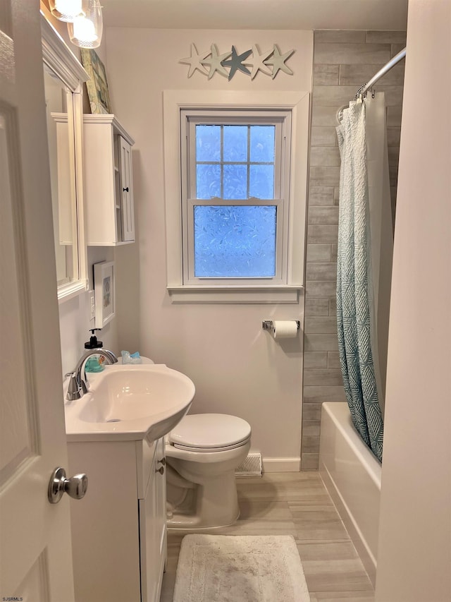 full bathroom featuring toilet, vanity, and shower / bath combo with shower curtain