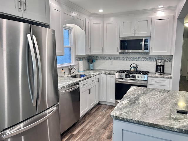 kitchen featuring stainless steel appliances, dark hardwood / wood-style floors, white cabinets, light stone counters, and sink