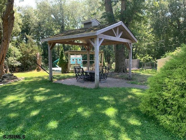 view of yard featuring a playground, a gazebo, and a patio