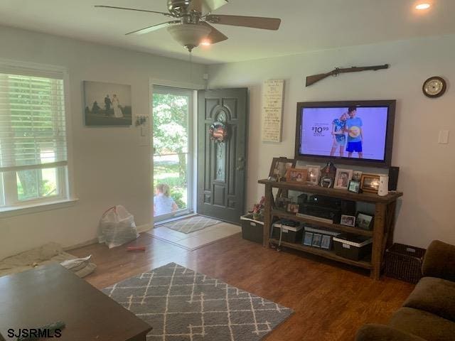 living room with ceiling fan and dark wood-type flooring