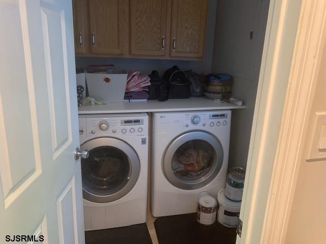 clothes washing area featuring cabinets and independent washer and dryer