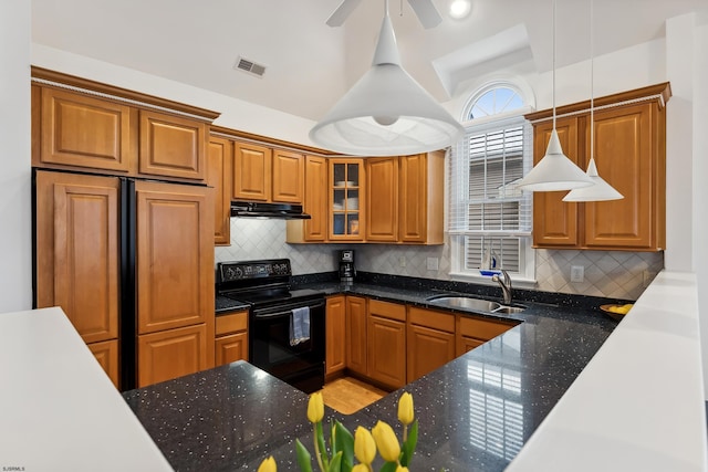 kitchen featuring dark stone countertops, pendant lighting, sink, black electric range oven, and paneled built in refrigerator