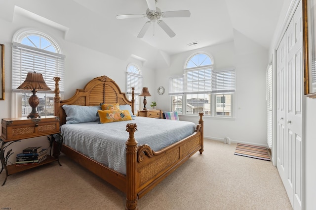 bedroom with ceiling fan, a closet, light colored carpet, and multiple windows