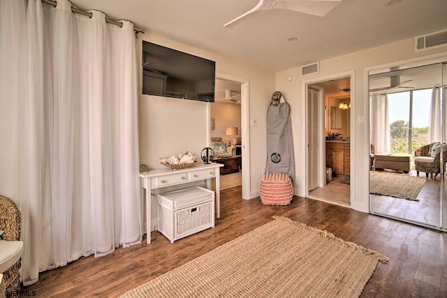 bedroom with ceiling fan, dark hardwood / wood-style flooring, and connected bathroom