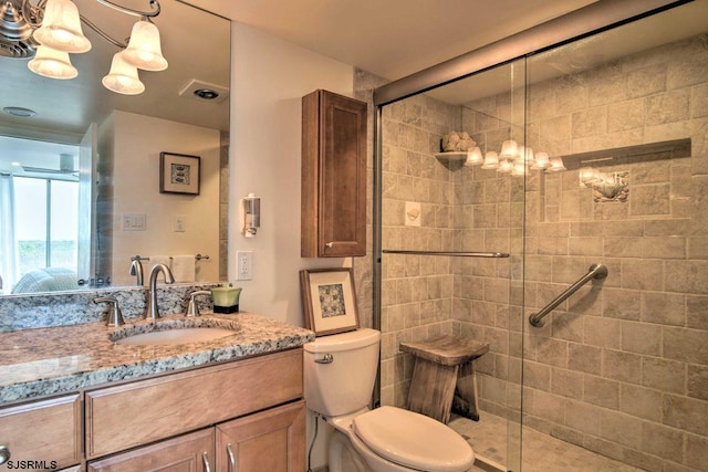 bathroom featuring an enclosed shower, vanity, and toilet