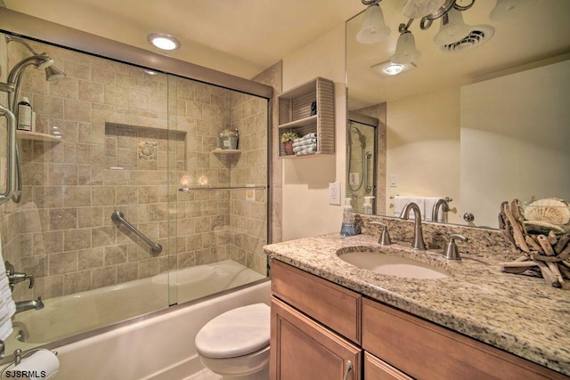 full bathroom with bath / shower combo with glass door, toilet, and vanity