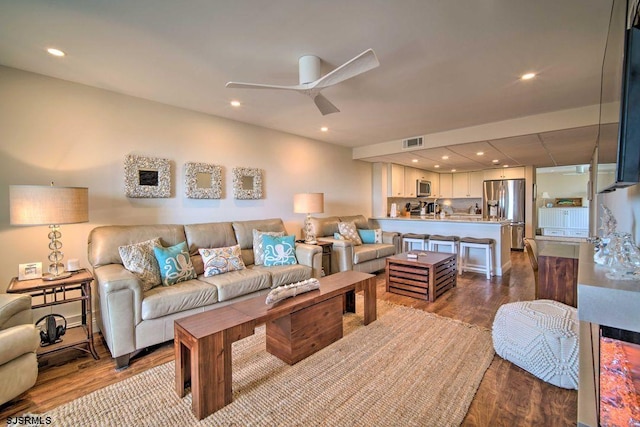 living room featuring ceiling fan and wood-type flooring