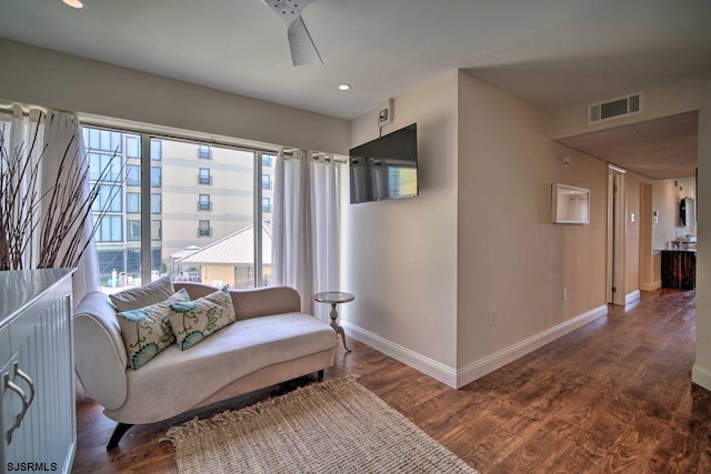 living area with ceiling fan and dark hardwood / wood-style flooring