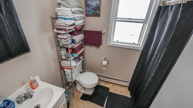 bathroom featuring toilet, baseboard heating, and sink