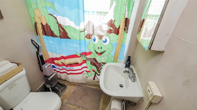 bathroom featuring sink, toilet, and walk in shower