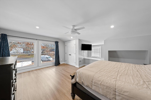 bedroom with ceiling fan, light wood-type flooring, and lofted ceiling