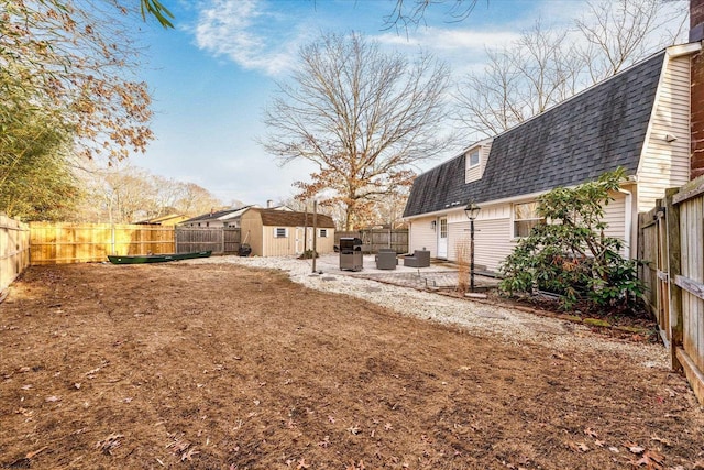 view of yard with a storage shed and a patio