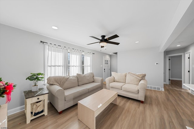 living room featuring ceiling fan and hardwood / wood-style flooring