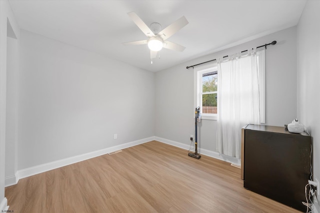 empty room with ceiling fan and light hardwood / wood-style floors