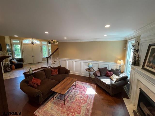 living room with crown molding, dark parquet flooring, and a fireplace